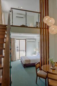 a bedroom with a bunk bed and a table and chair at Mansion Garden Hotel in Olongapo