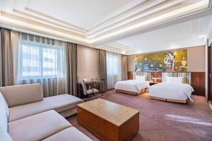 a hotel room with two beds and a couch at Grand Skylight Catic Hotel in Beijing +181 photos