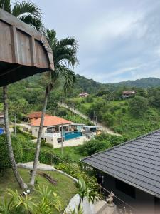 a view from the roof of a house with a palm tree at Karon Sea Sky Pool Apartment by 789property in Karon Beach