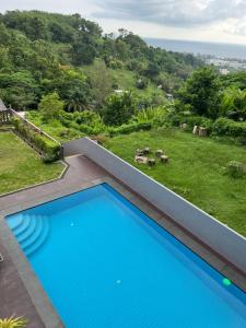 a blue swimming pool with a view of a yard at Karon Sea Sky Pool Apartment by 789property in Karon Beach