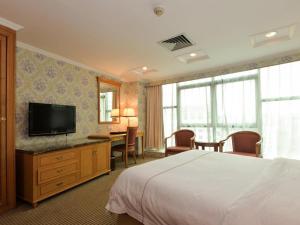 a hotel room with a bed and a desk and a television at New Pearl River Hotel in Guangzhou