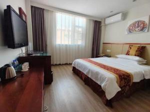 ein Hotelzimmer mit einem Bett und einem Flachbildfernseher in der Unterkunft GreenTree Inn Shenzhen Kengzi Town Express Hotel in Kengzi