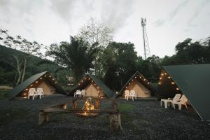 考索Nahm Khao Sok Hostel and Camping的一组带椅子和火的帐篷