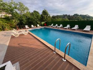 a swimming pool with lounge chairs and a swimming poolvisor at Green Cape Guest House in Makhinjauri