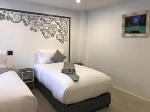 a bedroom with two beds and a picture on the wall at white house in Phangnga