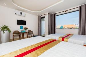 a hotel room with two beds and a television at New Vung Tau Hotel in Vung Tau