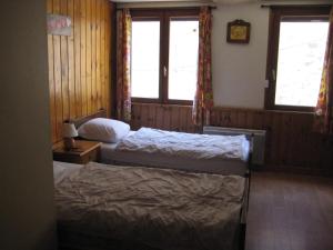 une chambre avec deux lits et deux fenêtres dans l'établissement Maison accueillante avec vue sur la montagne à La Grave, à La Grave