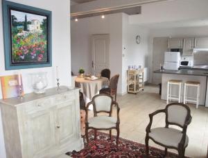 a living room with a table and chairs and a kitchen at La Maison de Jeanne in Châteney