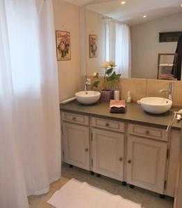 uma casa de banho com dois lavatórios num balcão em La Maison de Jeanne em Châteney