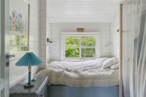 a small bedroom with a bed and a window at Charming House Near Private Beach And Nature in Rørvig