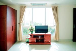 a living room with a television and a window at Hotel Thanh loi in Mỹ Ðuc