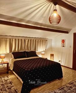a bedroom with a bed with a black comforter at Pousada Villa Dorinha Suites Spa in Nova Lima