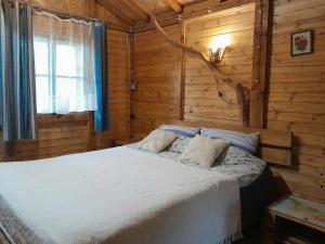 a bedroom with a bed in a log cabin at Tiny houses Genacvale in Martvili
