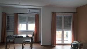 a dining room with a table and two windows at Villa Abi Center in Struga