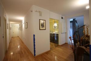 un pasillo con paredes blancas y suelo de madera en Rigel Hotel, en Catania