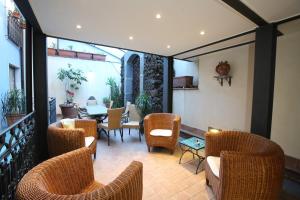 a patio with wicker chairs and a table on a balcony at Rigel Hotel in Catania