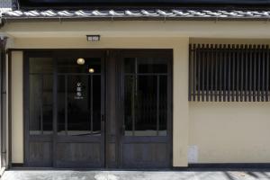 a building with a pair of doors on it at Machiya-Hotel Kyoto-ba 町屋ホテル 京都宿 in Kyoto