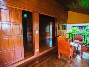 une terrasse couverte d'une maison avec une table et des chaises dans l'établissement Rommai Reunngam Resort, à Ban Chang Kham Luang