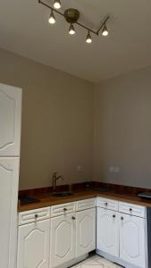 a kitchen with white cabinets and a sink at Quiet Zoon in Jeddah +5 photos