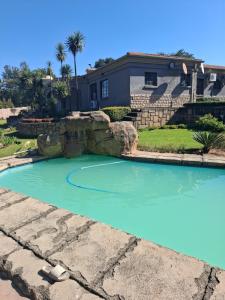 a pool of blue water in front of a house at Aaybee for Four in Midrand
