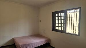 圣路易斯Suítes e quartos的一间有床和窗户的小房间