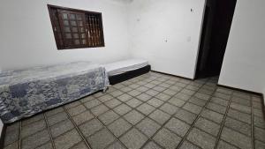 圣路易斯Suítes e quartos的客房设有两张床,铺有瓷砖地板。 更多6张照片