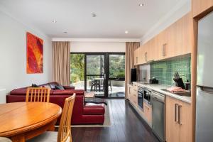 a kitchen and living room with a couch and a table at Lantern 13 - Deluxe Terrace in Thredbo