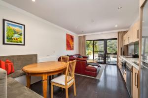 a kitchen and living room with a table and a couch at Lantern 13 - Deluxe Terrace in Thredbo