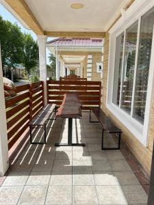 a patio with two benches and a table on a porch at Ne Dacha in Karakol