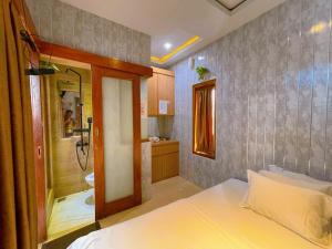 a bedroom with a bed and a bathroom with a shower at Rafitha Exclusive in Demangan