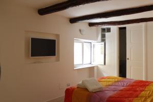 ナポリにあるSan Carlo Apartmentのベッドルーム1室(ベッド1台、壁掛けテレビ付)