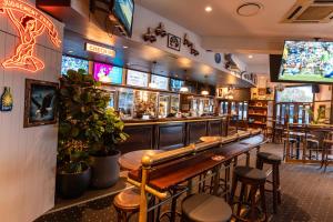 a bar with wooden tables and stools in a restaurant at Courthouse Hotel in Sydney