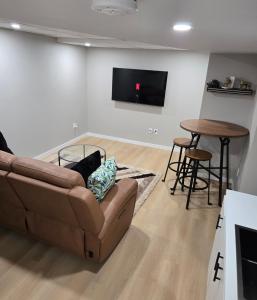 a living room with a couch and a table at Cozy 2 bedroom basement with side entrance in Bélanger