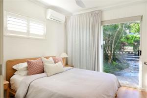 a bedroom with a bed and a large window at Casa Katharina – Your Coastal Escape on Noosa Hill in Noosa Heads +9 photos