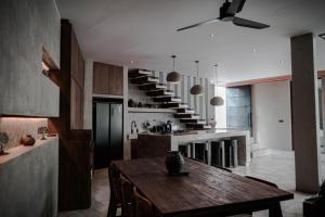 a kitchen with a wooden table and a staircase at Aranya Bali in Tumbak Bayuh