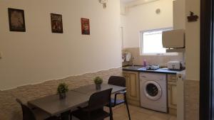 a kitchen with a table and a washing machine at Vis A Vis Studio in Bucharest