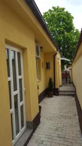 a yellow building with a white door and a sidewalk at Vis A Vis Studio in Bucharest