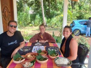 a group of three people sitting at a table with food at Ship Villa in Habarana