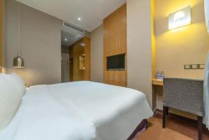 a bedroom with a large white bed and a desk at The Art Hotel Cai Tian Branch in Shenzhen