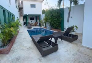 une terrasse avec une piscine et des chaises ainsi qu'une maison dans l'établissement Casa de tres habitaciones con piscina, à La Romana 11 autres photos