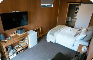 a bedroom with a bed and a flat screen tv at Lakeside Tiny Home in Cromwell