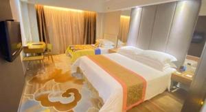 a hotel room with two beds and a television at Downtown Hotel in Zhuhai