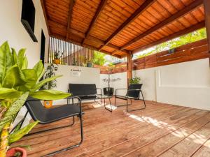 a patio with chairs and a wooden deck at La Ŵilla, piscine et parking privatisées, accès mer, sentiers et volcans!! in Saint-Joseph