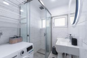 ein Badezimmer mit Glasdusche und Waschbecken in der Unterkunft Corfu Apt Center Deluxe in Korfu-Stadt + 9 Fotos