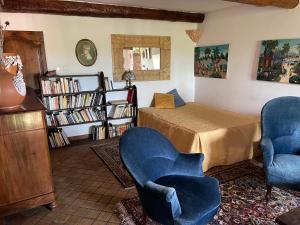 a room with a bed and two chairs and a book shelf at Var Village House in Salernes