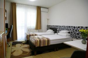 Postel nebo postele na pokoji v ubytování Auguszta Hotel