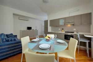 a kitchen and dining room with a table and chairs at My House Apartments in Cremona