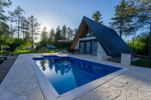 a house with a swimming pool and a pitched roof at Holiday home Pine nest in Široki Brijeg