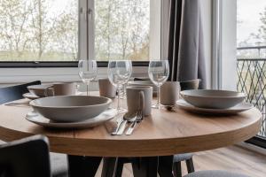 a wooden table with plates and wine glasses at Echo jeziora in Charzykowy