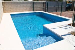 una piscina de agua azul en un edificio en Chalet Arroyo Majadales 107, en Conil de la Frontera